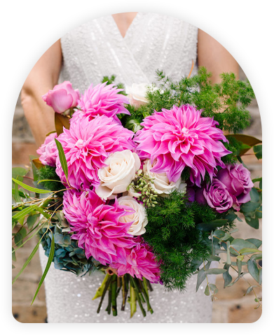 Bride holding a bouquet of pink dahlias, white roses, and greenery