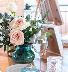 Vase with pink and white roses on a decorated table.