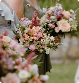 Bridesmaids holding pastel floral bouquets.